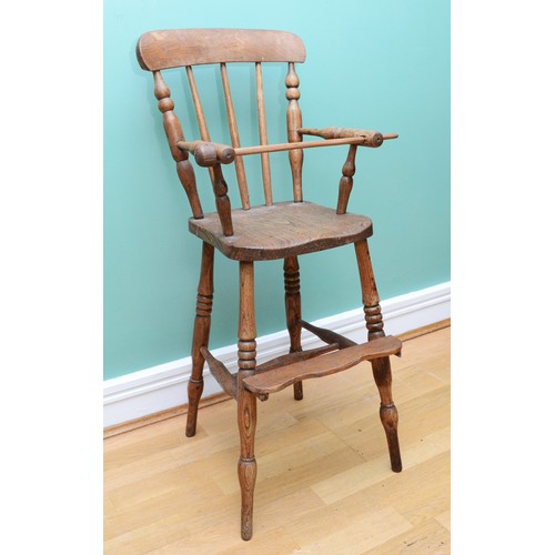 26 - An Edwardian elm children's high chair, with a three-post spindle and stretcher, H-88cm.