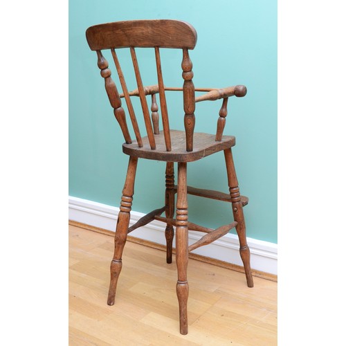 26 - An Edwardian elm children's high chair, with a three-post spindle and stretcher, H-88cm.