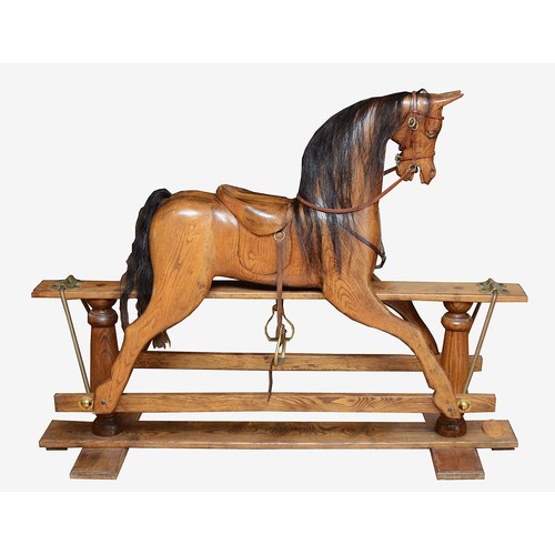 An oak rocking horse, with chestnut mane and tail, on a trestle rocker frame supported by dual baluster columns, dual plinth base, with applied label for the maker D.R.S.T C E Torquay, Devon, H-115cm x 150.