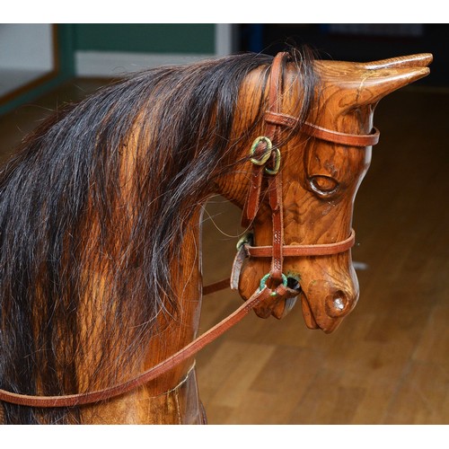 59 - An oak rocking horse, with chestnut mane and tail, on a trestle rocker frame supported by dual balus... 