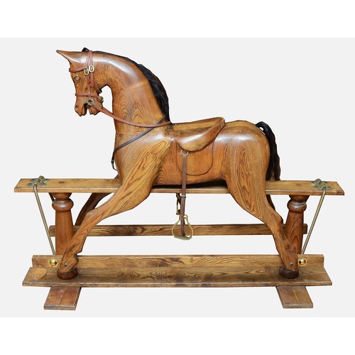 59 - An oak rocking horse, with chestnut mane and tail, on a trestle rocker frame supported by dual balus... 