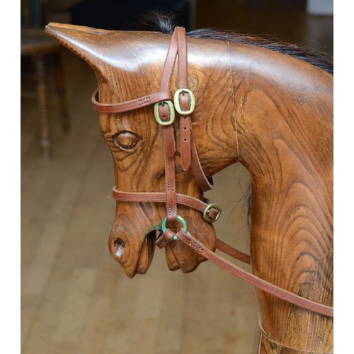 59 - An oak rocking horse, with chestnut mane and tail, on a trestle rocker frame supported by dual balus... 