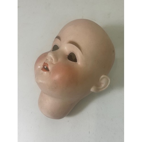 165 - A large antique German bisque dolls head, with sleeping eyes, an open mouth revealing teeth and pain... 