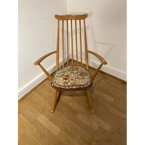 An Ercol blond elm stick back rocking chair, of small proportions, with ...