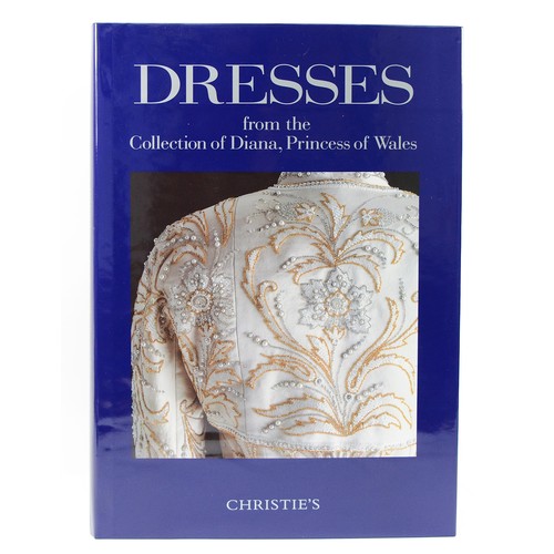 Dresses from the Collection of Diana, Princess of Wales, Christies. The large-format catalogue for the 1997 Christie's charity auction of dresses belonging to Diana, Princess of Wales. The eighty lots included dresses by Catherine Walker, Victor Edelstein, Gina Fratini for Hartnell, Christina Stambolian, Ballville Sasoon and Lorcan Mullany, Zandra Rhodes, Bruce Oldfield, Hachi, Jaques Azagury, Emanuel, Murray Arbeid and Yuki. Each dress is illustrated as well as numerous photographs of the princess wearing the items, close up details and reproductions of designers' drawings. 
Christie's. New York. 25 June 1997. Hardback, folio; purple cloth-bound boards, dust jacket, original wrapper. Absentee bid form and invitation to view loosely inserted. 204 pages. 430 x 310mm. 3kg. 
In very good condition.