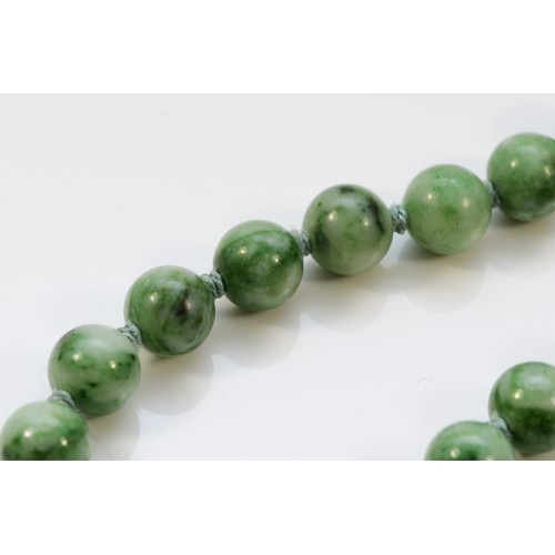 13 - A mottled jadeite bead necklace, 7mm beads, 60cm, silver gilt clasp