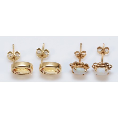 120 - A pair of 9ct gold citrine earrings with scroll backs together with a pair of 9ct gold opal earrings... 