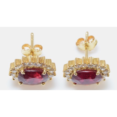 121 - A pair of 18ct gold brilliant cut diamond and glass filled ruby earrings with scroll backs, 13mm x 1... 