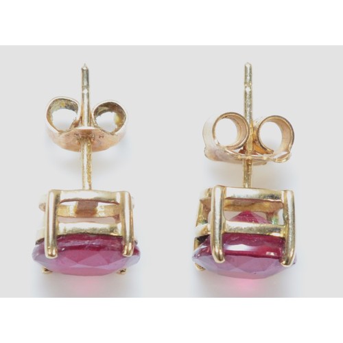 134 - A pair of 9ct gold glass filled ruby earrings with scroll backs, 2g