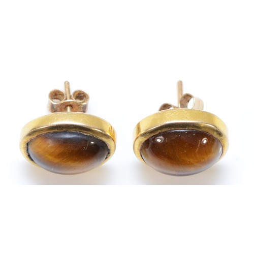 179 - A pair of 9ct gold tigers eye earrings with scroll backs, 5.4g