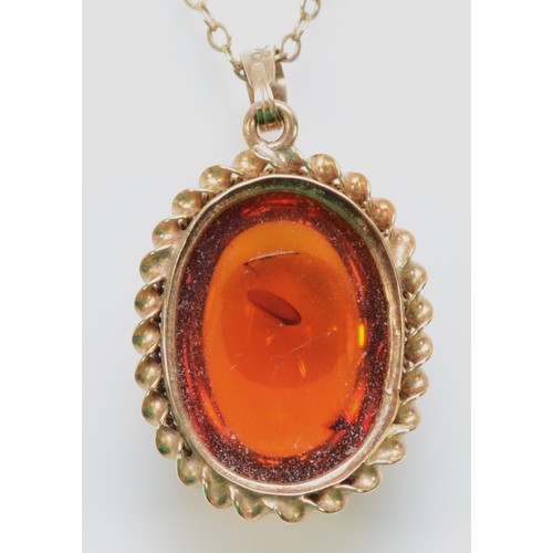 222 - A 9ct gold cabochon cut amber pendant with a chain, 18mm x 15mm pendant, 2.7g