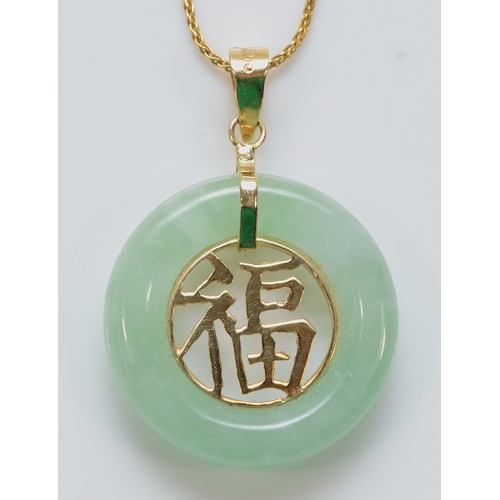 226 - A 14k gold jade pendant with a chain, 18mm diameter, 3.7g