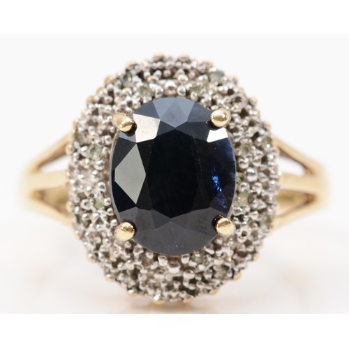 238 - A 9ct gold sapphire and diamond cluster ring, 10mm x 6mm sapphire, P, 3.9g