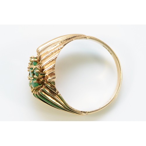 263 - A 9ct gold emerald floral cluster ring with decorative shoulders, O 1/2, 3.8g