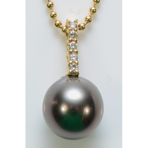 500 - An 18ct gold cultured pearl and brilliant cut diamond pendant with a chain, 17mm pendant drop, 4.3g