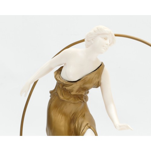 250 - An Art Deco inspired figurine of a flappy girl with hoop, stood upon a marble plinth, 26cm tall.