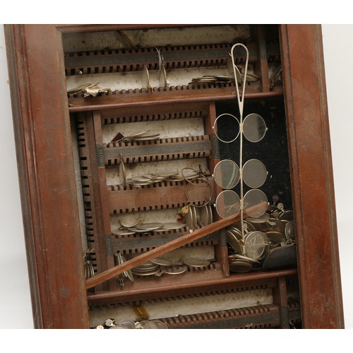 304 - A counter-top opticians cabinet, complete with steel half-frame lenses for testing vision.