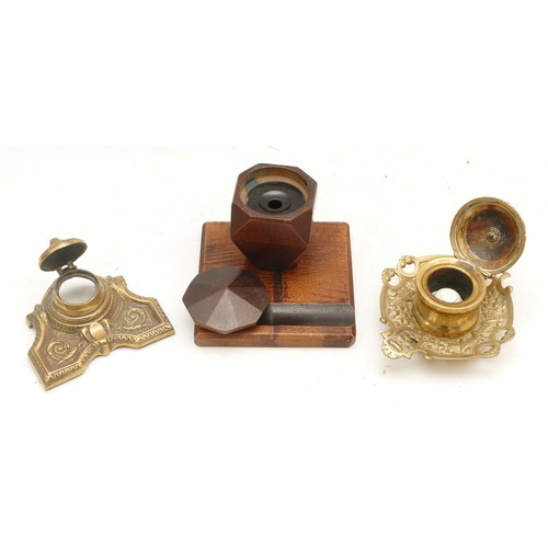 305 - Three mid to late twentieth century inkwells, to include, two brass examples, and a geometric wooden... 