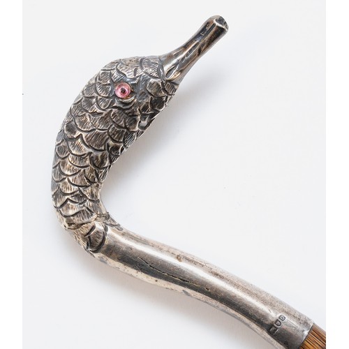 440 - An Edwardian silver parasol handle in the shape of a swans head with two glass eyes, mounted on a pi... 