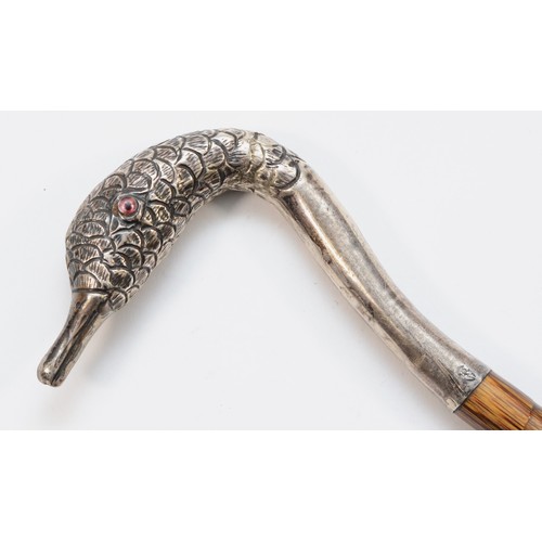 440 - An Edwardian silver parasol handle in the shape of a swans head with two glass eyes, mounted on a pi... 