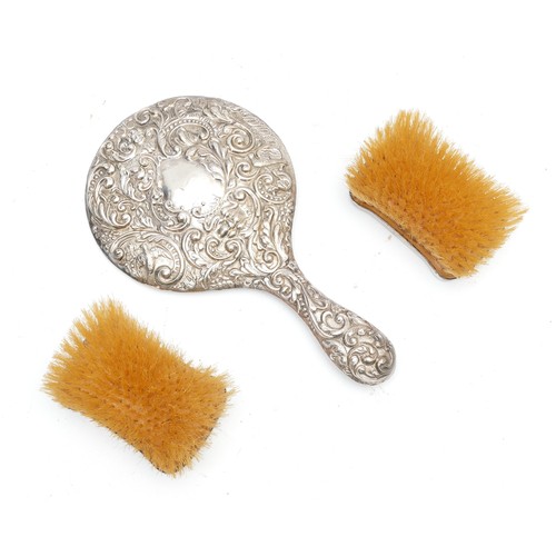 451 - A silverbacked hand mirror,together with a pair of silver backed clothes brushes. (3)