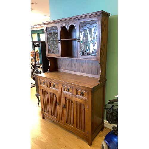 729 - A late 20th century oak kitchen dresser, the top section having twin glazed leaded cupboard doors ov... 