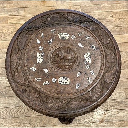 740 - An early 20th century Indian carved hardwood elephant coffee/side table, the round top with central ... 