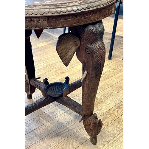 740 - An early 20th century Indian carved hardwood elephant coffee/side table, the round top with central ... 