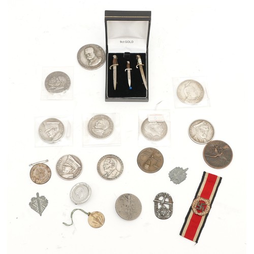 514 - A selection of German coins and medallions, sweetheart brooches and cap badges to include the 1935 A... 