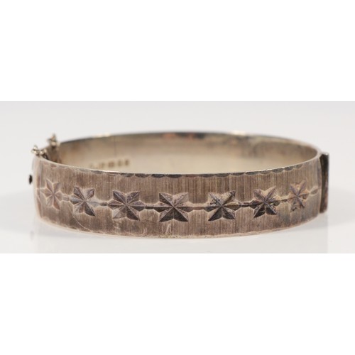 91 - A sterling silver hinged bangle with a star design, GJ Ld, London 1973, 30g