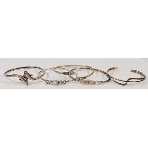 99 - Five silver and gemset bangles, to include a dolphin example, internal diameter from 60-65mm, 46g