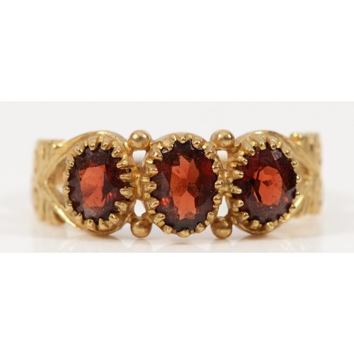 195 - A 9ct gold garnet three stone ring, O, 2.1g