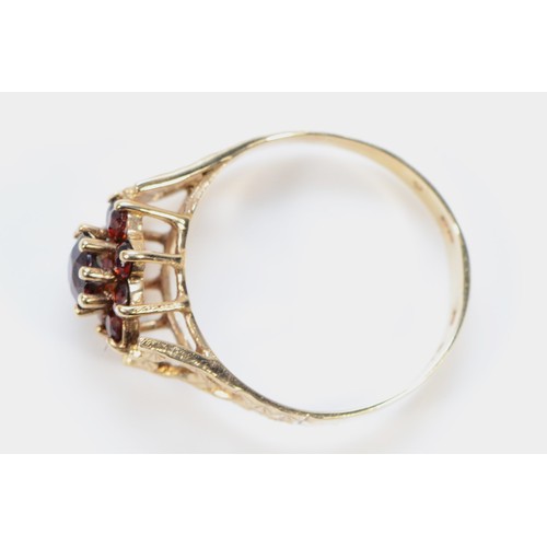 226 - A 9ct gold garnet floral cluster ring, with decorative shoulders, O 1/2, 2.3g