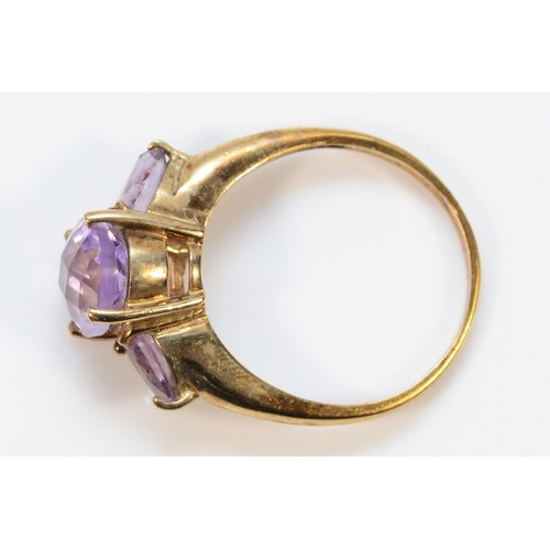 310 - A 9ct gold amethyst three stone ring, P 1/2, 3.9g