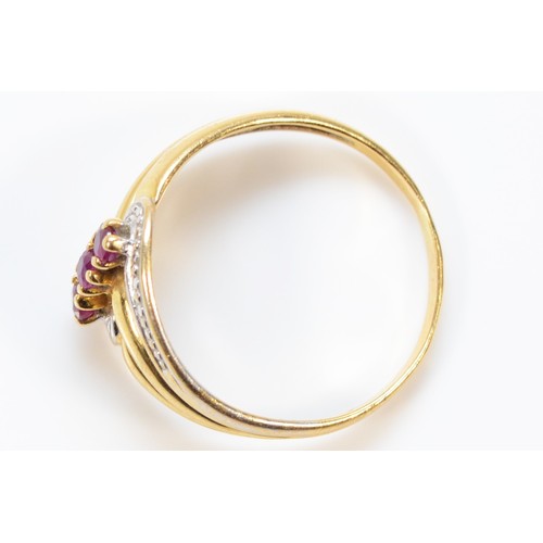 387 - A 9ct gold ruby three stone dress ring, O 1/2, 2.5g