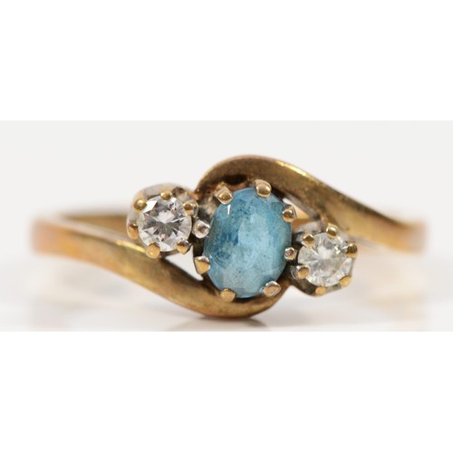 458 - A 9ct gold brilliant cut diamond and blue gemstone three stone cross over ring, K 1/2, 2.1g