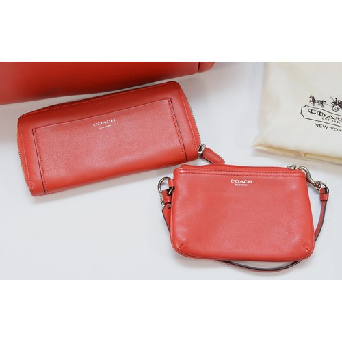 A red leather Coach shoulder bag, with external zippered pouch and