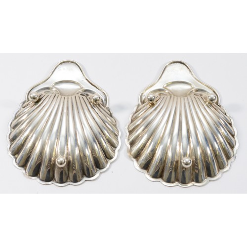 14 - An Edwardian silver pair of shell dishes, Sheffield 1907, raised on three ball feet, 13 x 10.5cm, 90... 