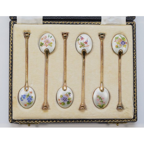 33 - A set of five silver gilt and enamel seal top coffee spoons with floral decoration to the backs, by ... 