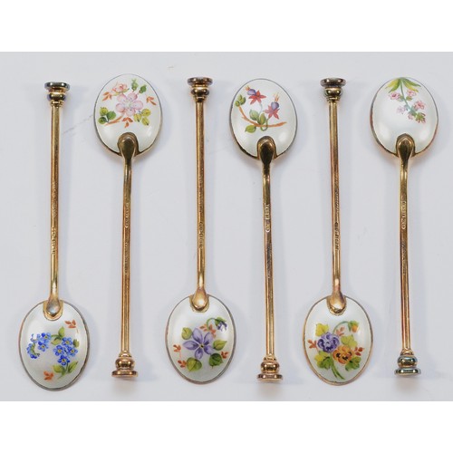 33 - A set of five silver gilt and enamel seal top coffee spoons with floral decoration to the backs, by ... 