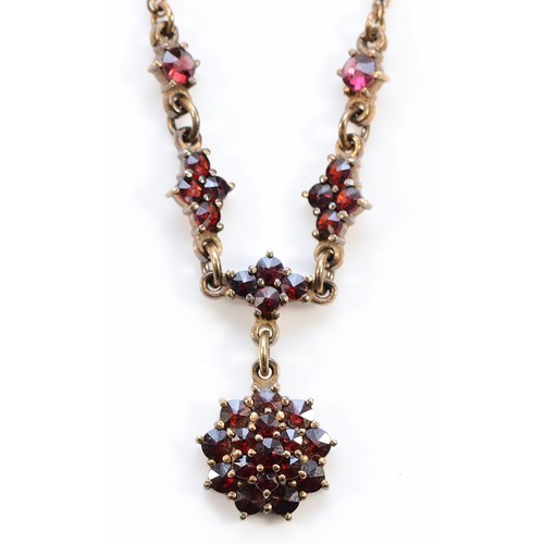 65 - An Austro-Hungarian gilt metal and Bohemian garnet triple cluster and swag necklace, the front 12cm,... 