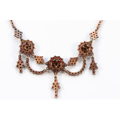 65 - An Austro-Hungarian gilt metal and Bohemian garnet triple cluster and swag necklace, the front 12cm,... 