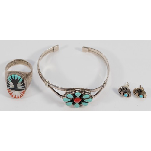 73 - A Native American silver, turquoise and coral bangle, stamped 925, an unmarked silver ring with cora... 