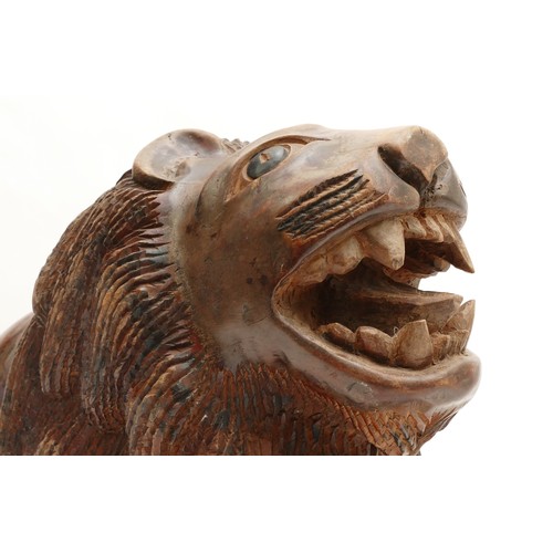 250 - A large probably Indian folk art naive carved wooden sculpture of an Asiatic lion, H36, L56cm.