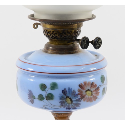 261 - An Edwardian oil lamp with a Duplex English burner, a light blue glass reservoir decorated with blue... 