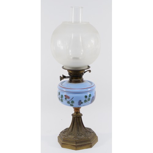 261 - An Edwardian oil lamp with a Duplex English burner, a light blue glass reservoir decorated with blue... 