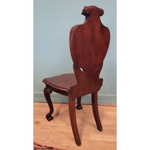 378 - A Victorian mahogany hall chair, the deeply carved scroll back with solid seat, raised on cariole le... 