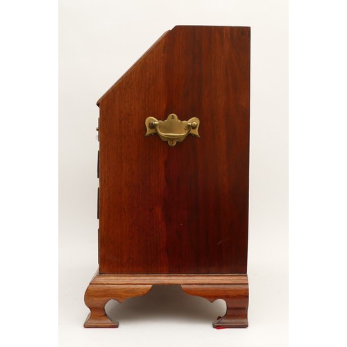 385 - A mahogany apprentice or miniature bureau, the fall flap opening to reveal pigeon holes, central cup... 