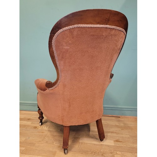 375 - A Victorian mahogany nursing chair, having buttoned pale pink upholstery, raised on turned legs with... 