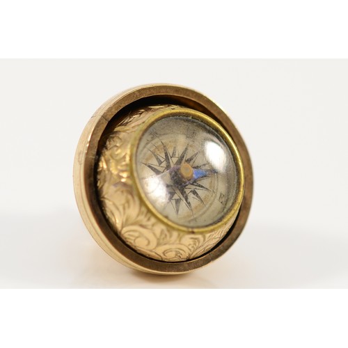 A 9ct gold engraved orb charm that spins to reveal a compass, 15mm, 5.4g